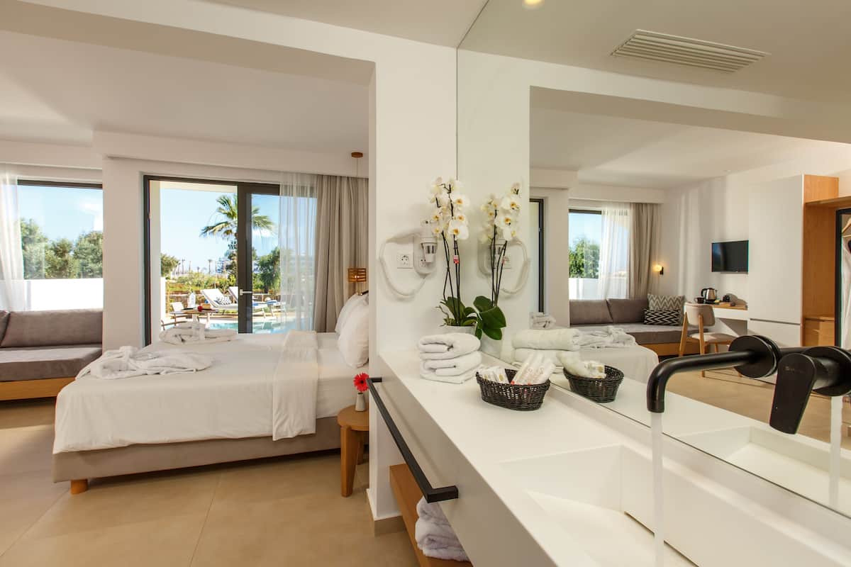 Habitación de hotel moderna con cama, un espejo grande, una barra de baño y vistas al área de la piscina.
