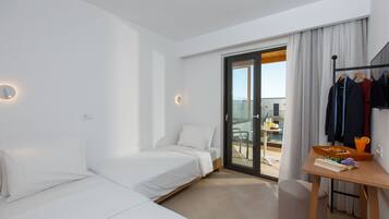 Een moderne hotelkamer met een bed, een bureau met een ontbijtplateau en uitzicht op het balkon.