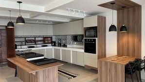 A modern kitchen with a central island, built-in appliances, and pendant lighting. - Front sea Mansion With Pool Maceio Paripueira (Paripueira)