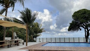 A pool area with wooden steps leading to the water, surrounded by palm trees and a view of the sea. - Front sea Mansion With Pool Maceio Paripueira (Paripueira)