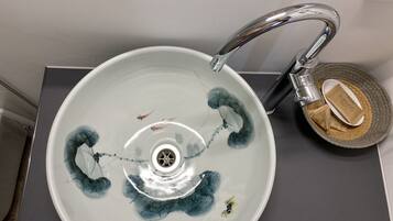 A bathroom sink with a modern faucet and a decorative bowl.