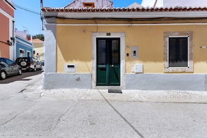 A building with a green door, a number '124' above the door, and a small window to the right.