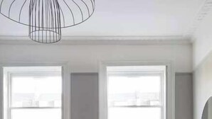 Una sala de estar moderna con comedor, ventanas amplias y vistas a la ciudad.