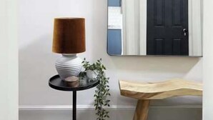 Un interior moderno con una mesa redonda, un espejo y un banco.
