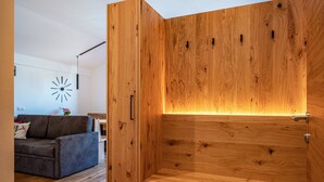 A modern living room with a wooden cabinet, a sofa, and a wall clock.