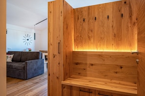A modern living room with a wooden cabinet, a sofa, and a wall clock.
