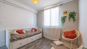 Un salon moderne avec un canapé blanc, un fauteuil blanc et un petit tapis.