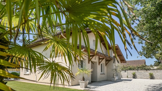A house with a tiled roof, a paved driveway, and a well-maintained lawn. - Vacation Villa "Villa Teny La Teste Arcachon" with Pool, Garden, and Terrace (La Teste-de-Buch)