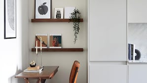 Eine moderne Küche mit einem Holztisch, einem Stuhl und einem Einbauschrank.