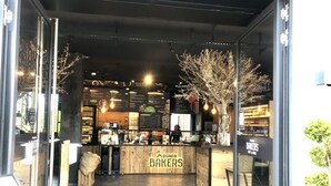 A bakery with a wooden counter, menu boards, and hanging light bulbs. - Mountain atmosphere apartment - with fantastic panoramic mountain views (Garmisch-Partenkirchen)