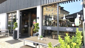 A modern storefront with large glass windows and a sign reading "Bakers Cafe & More". - Mountain atmosphere apartment - with fantastic panoramic mountain views (Garmisch-Partenkirchen)