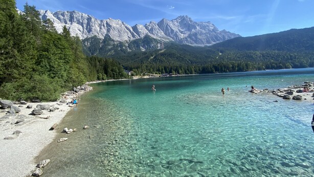 A clear lake with rocky shore, surrounded by forest and mountains. - Mountain atmosphere apartment - with fantastic panoramic mountain views (Garmisch-Partenkirchen)