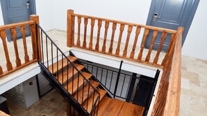 A wooden staircase with black railings leading to a landing. - Gökçeada Deep Breath (Gökçeada)