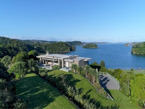 Situated in a lush landscape, this two-story building offers expansive views of a serene body of water and surrounding islands.
