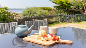 A table with a blue teapot, two cups, biscuits, and strawberries. - Higher Upover (Woolacombe)
