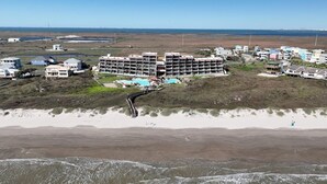 A coastal hotel with multiple floors, a swimming pool, and a beach view. - Seaside Haven | Beachfront | Panoramic Ocean Views (Port Aransas)