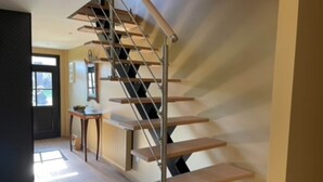 A modern staircase with a minimalist design, featuring wooden steps and metal railings.