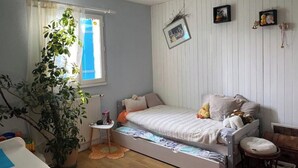 A bedroom with a bed, a small table, a potted plant, and a window with curtains. - Holiday home in Périgord (Saint-Georges-de-Montclard)