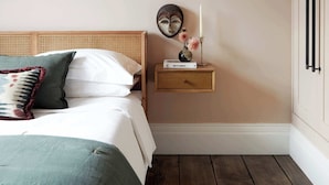 Une chambre à coucher avec un lit, une table de chevet et une commode.