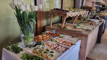 Un bufé con diversas opciones de comida, como frutas, verduras y platos ya preparados.