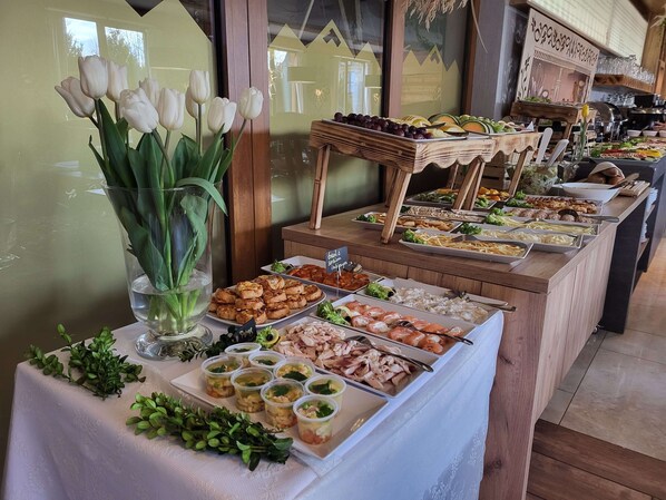 A buffet with various food options including fruits, vegetables, and prepared dishes.