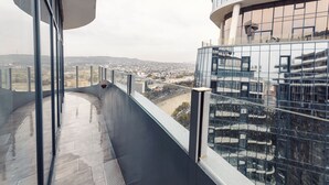 A high-rise building with a glass facade and a view of a cityscape. - Meta Business Hotel (Tbilisi)