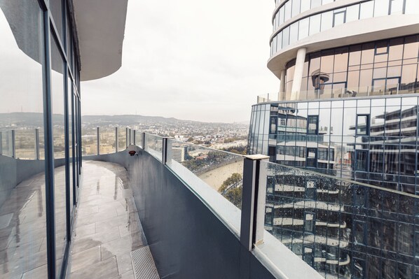 A high-rise building with a glass facade and a view of a cityscape.