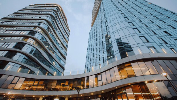 Two modern high-rise buildings with curved facades and reflective glass windows. - Meta Business Hotel (Tbilisi)
