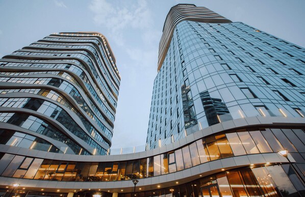 Two modern high-rise buildings with curved facades and reflective glass windows. - Meta Business Hotel (Tbilisi)