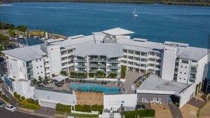 Un hôtel moderne doté d’une piscine centrale, de nombreux balcons et offrant une vue sur le front de mer.