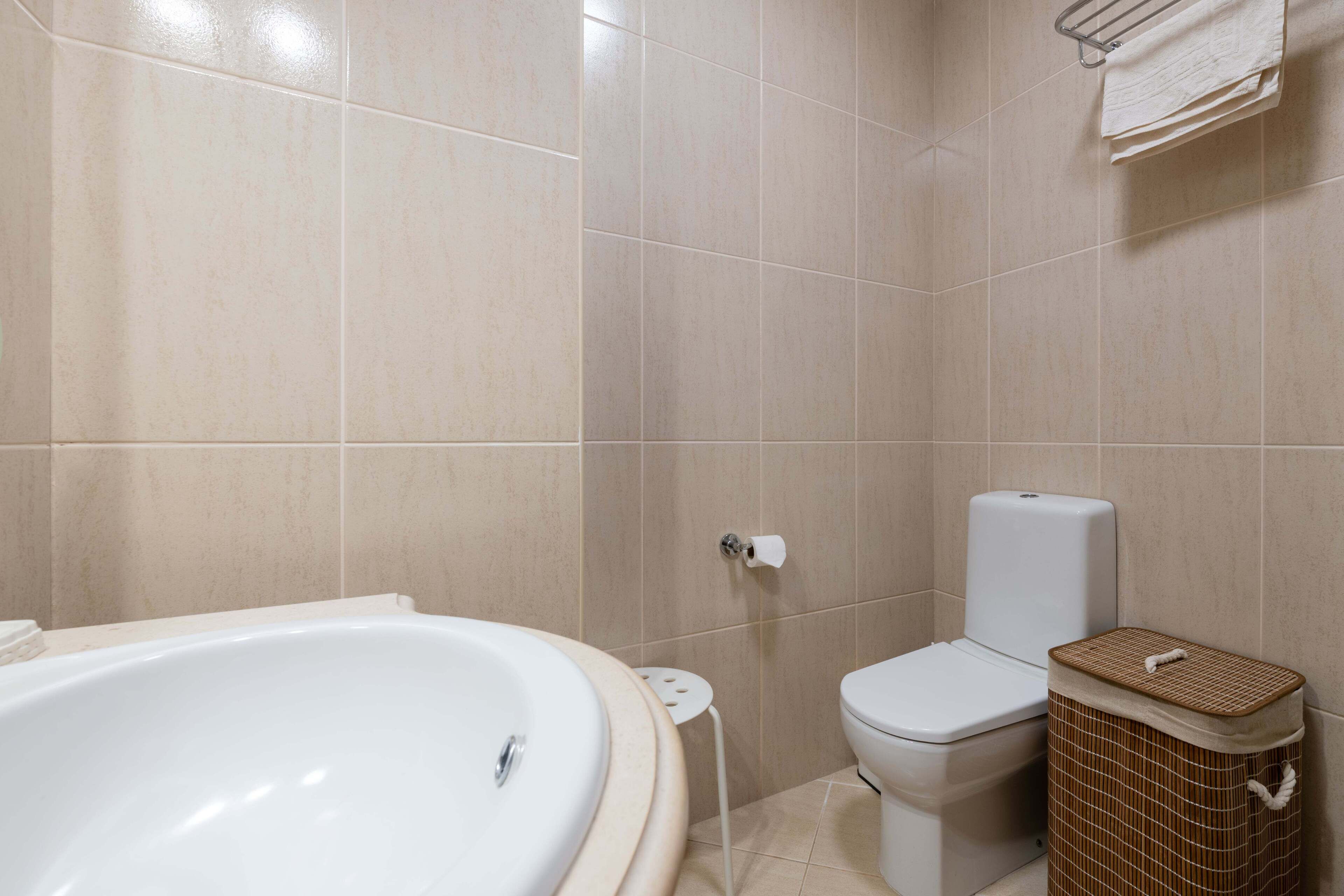 Ein Badezimmer mit Badewanne, Toilette und Mülleimer.