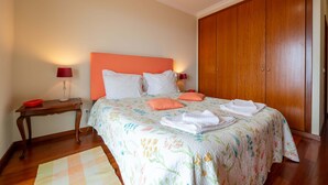 Une chambre à coucher avec un lit, une table de chevet, une lampe et une armoire.