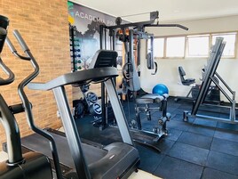 Un gimnasio con equipo de ejercicio, una pared con un cartel y una ventana.