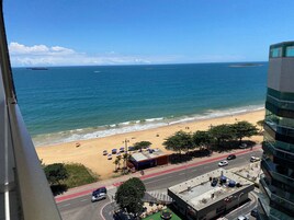 Vista costera con playa, océano y carretera con vehículos.