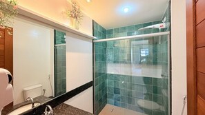 A bathroom with a shower, a sink, and a mirror. - Praia Dourada (Vila Velha)