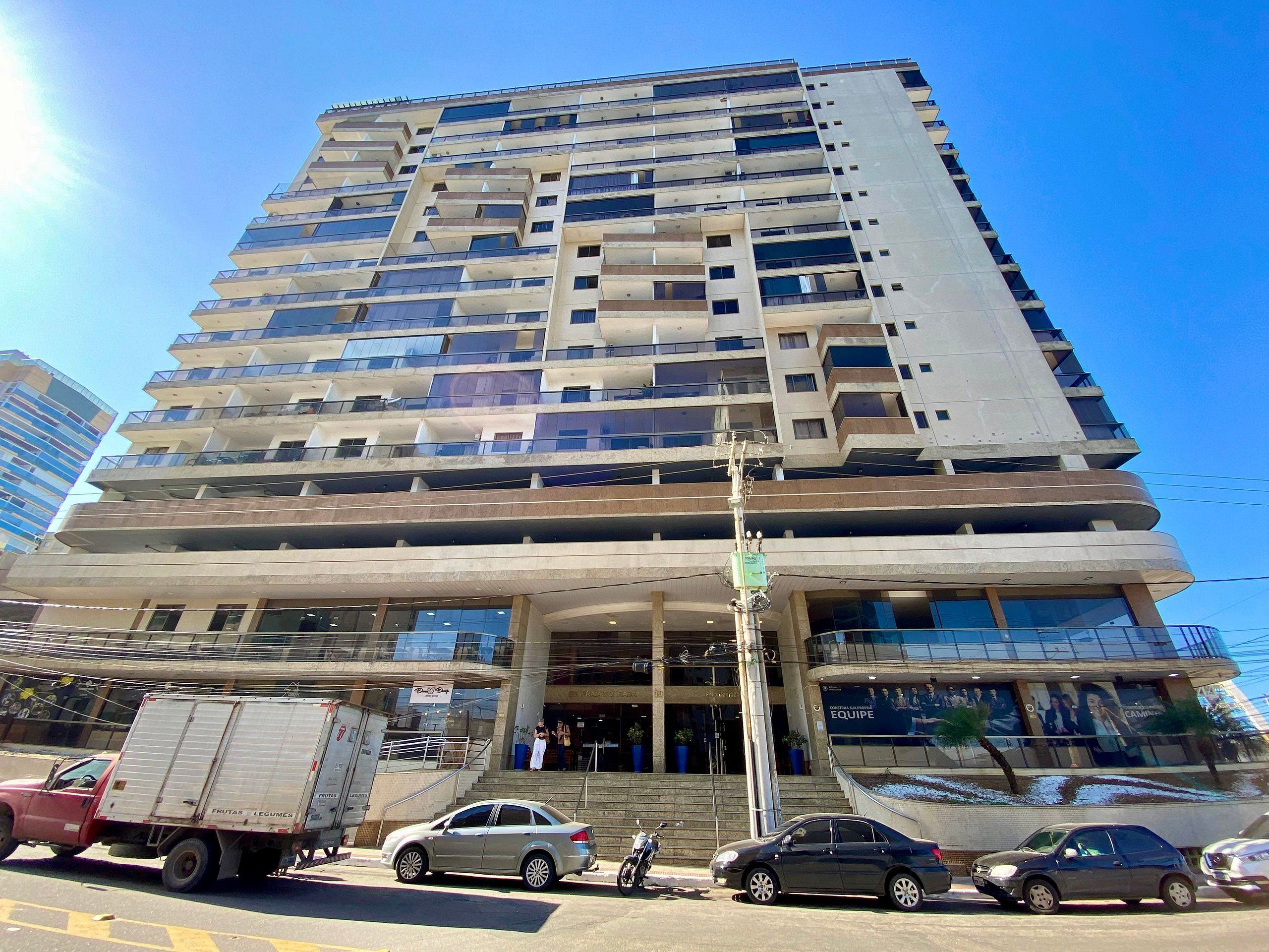 A multi-story building with balconies and large windows.