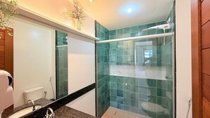 Une salle de bain avec une douche, un lavabo et un miroir.