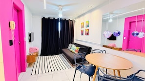 A modern living room with a black sofa, a wooden dining table, and a black and white striped rug. - Praia Dourada (Vila Velha)