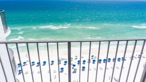A balcony with a view of the ocean and beach umbrellas. - Seasational Escape!  Amazing Beachfront Condo/Covered Balcony, BEACH SER, Pool (Panama City Beach)