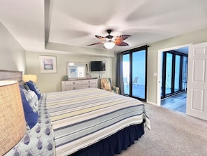 A bedroom with a bed, dresser, and a ceiling fan. There is a sliding glass door leading to a balcony. - Seasational Escape!  Amazing Beachfront Condo/Covered Balcony, BEACH SER, Pool (Panama City Beach)