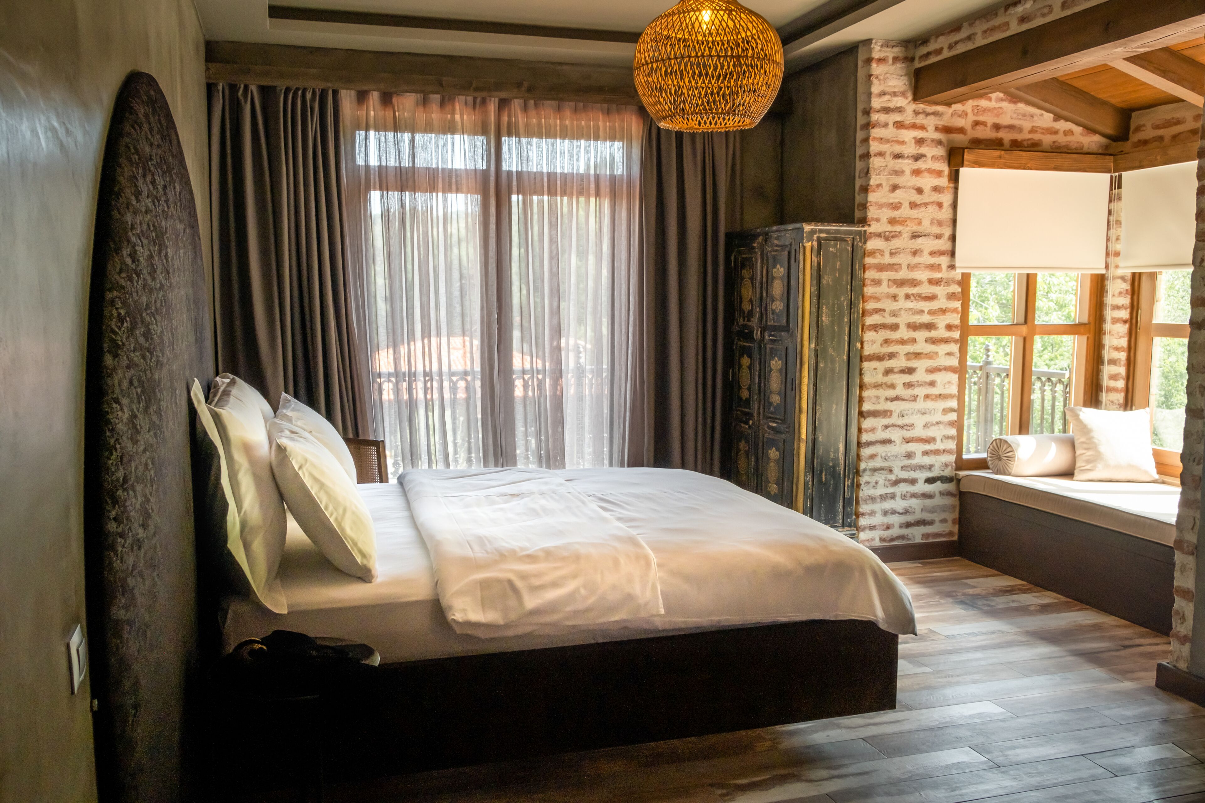 Un dormitorio con una cama grande, un armario y una ventana con vistas.