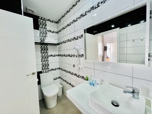 Habitación doble superior | Baño | Ducha, secador de pelo, toallas y jabón