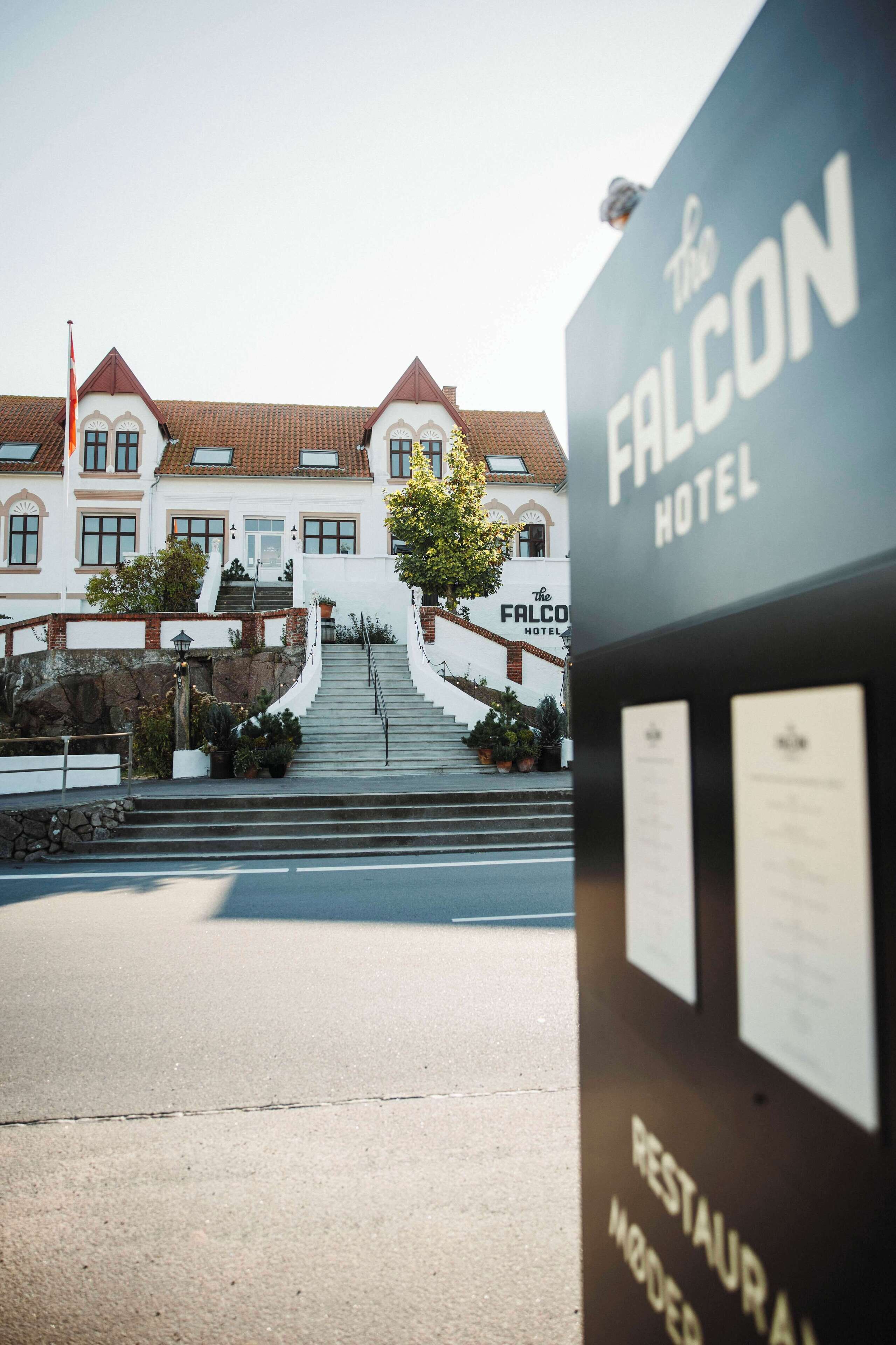 The exterior of The Falcon Hotel with a staircase leading to the entrance.