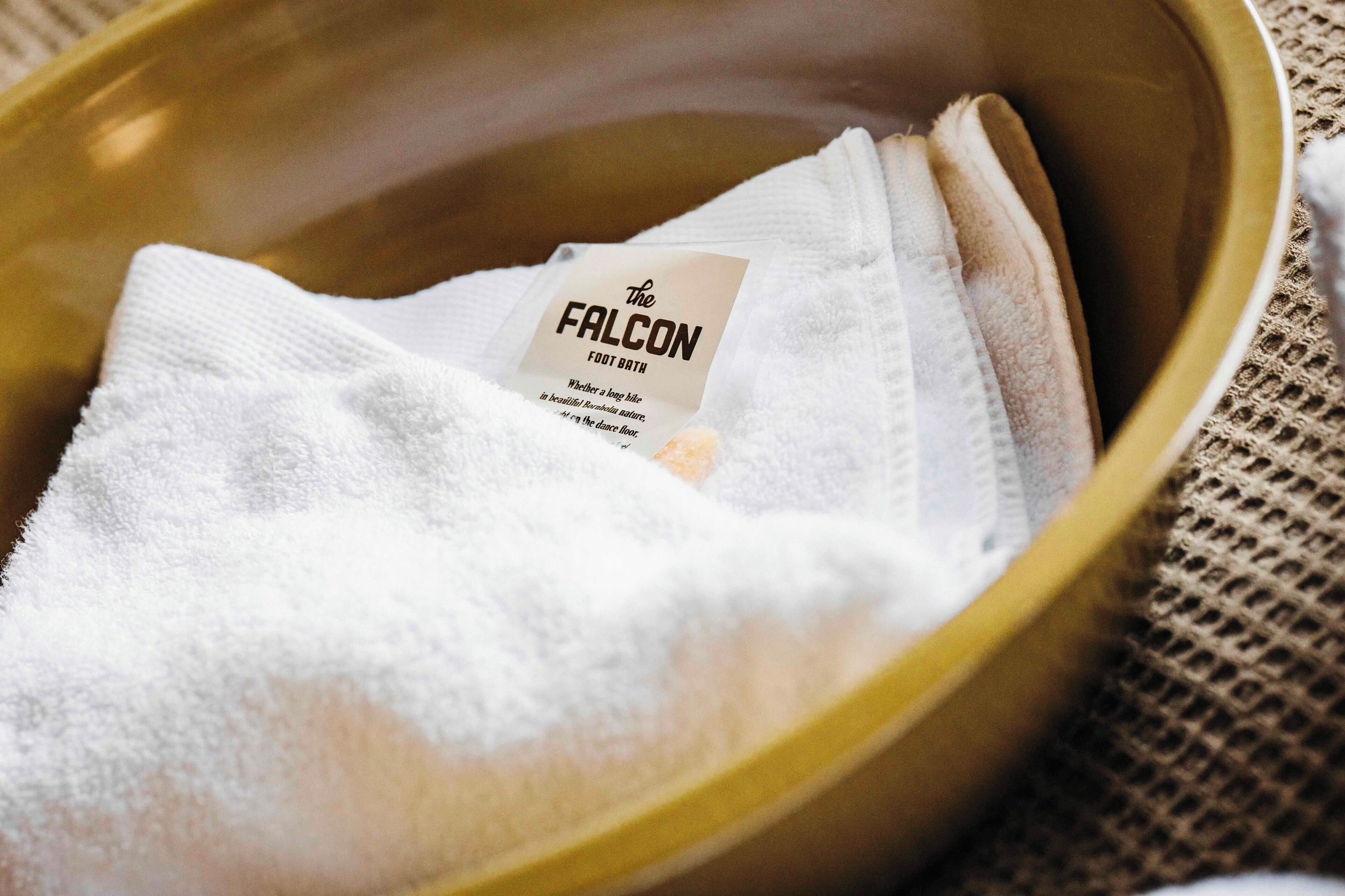 A white towel with a label in a golden bowl.
