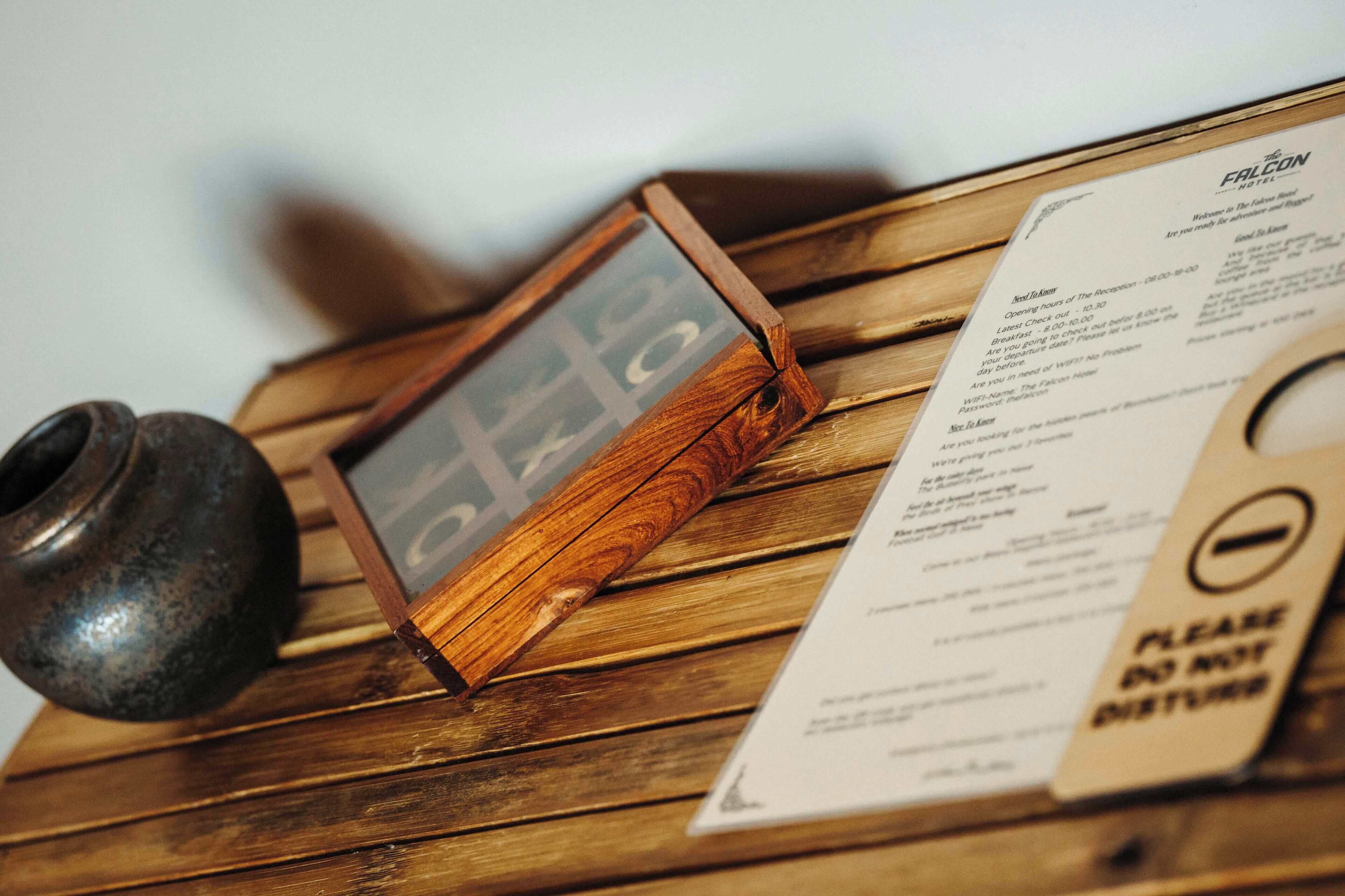 A wooden table with a menu, a wooden bowl, and a sign with a prohibition symbol.
