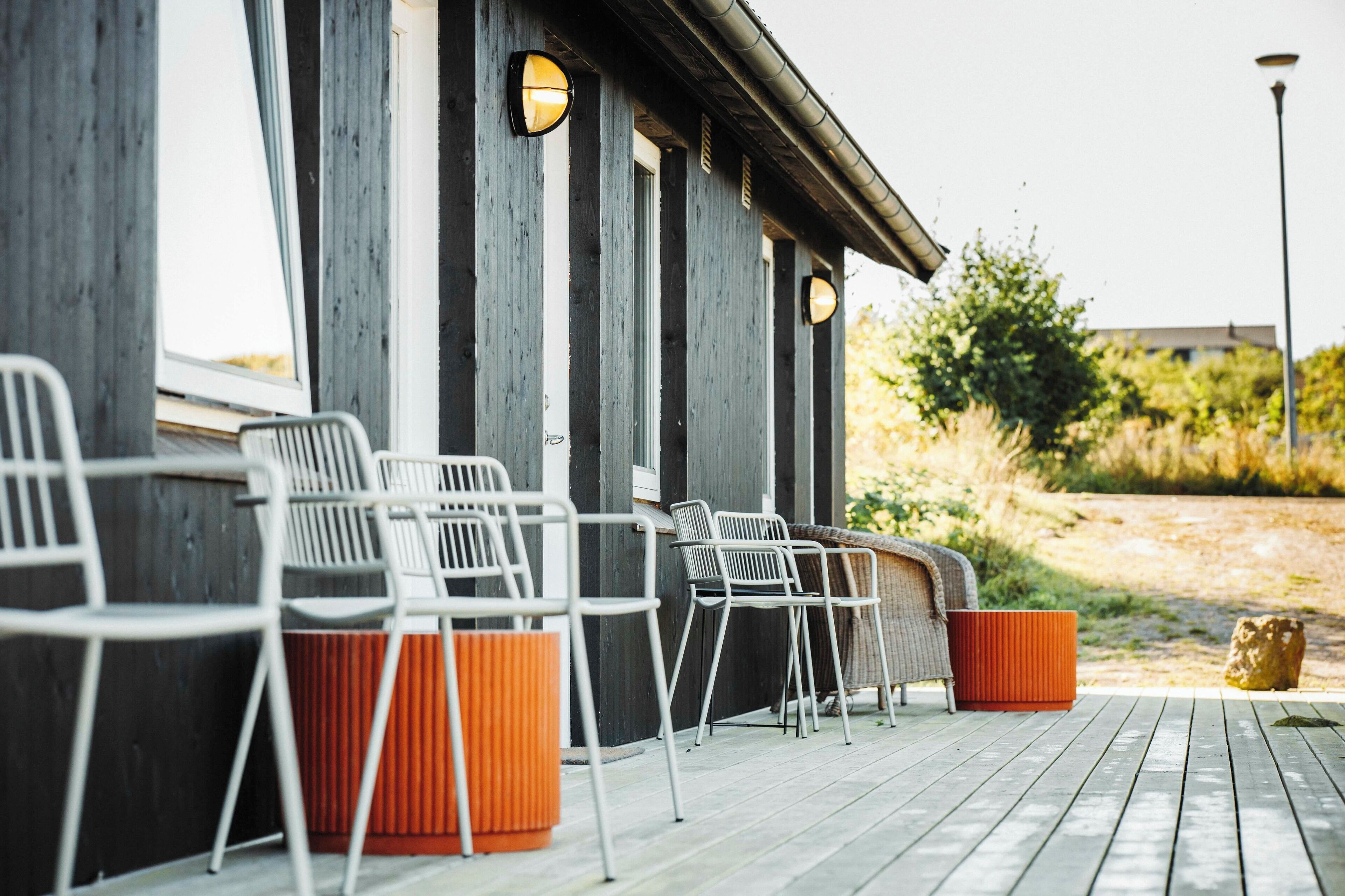 A wooden deck with outdoor seating and trash bins.