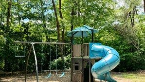 A playground with swings and a slide. - Chimney Mtn 1 -  2BR Cabin, Dog Friendly, Fireplace, Covered Hot Tub. Near Helen (Sautee Nacoochee)