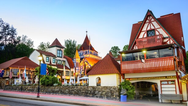 A traditional European-style building with a stone facade, a balcony with wooden railings, and a red-tiled roof. - Chimney Mtn 1 -  2BR Cabin, Dog Friendly, Fireplace, Covered Hot Tub. Near Helen (Sautee Nacoochee)