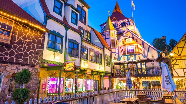 Un bâtiment européen traditionnel, à étages, doté d’une façade en pierre et d’une tour imposante surmontée d’une flèche.