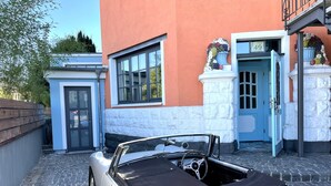 A vintage MG car parked in front of a building with a stone facade, a blue door, and a sign indicating the address. - Residenz im "alten Wasserturm" (Wuppertal)